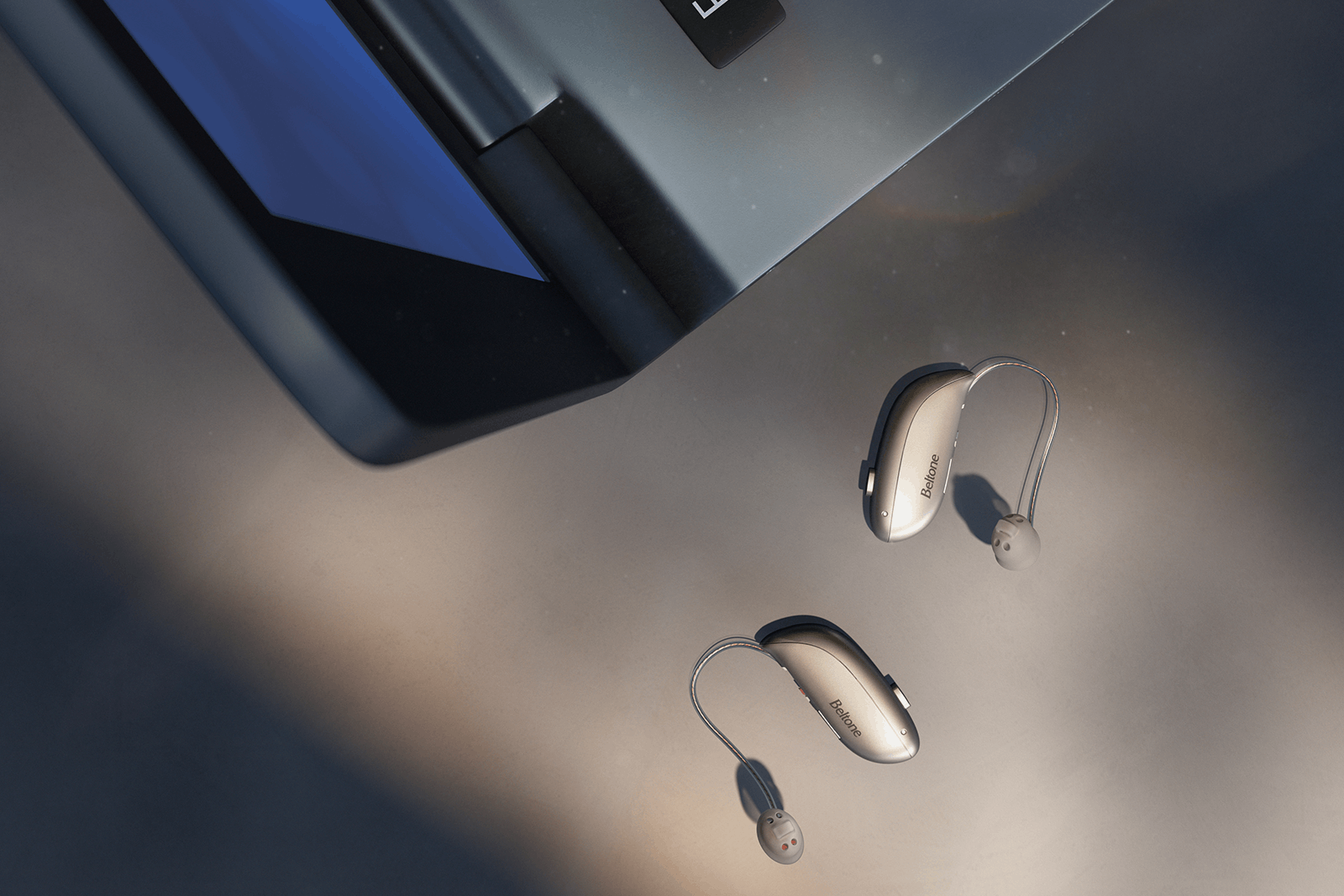 Beltone Illuminate hearing aids next to a laptop