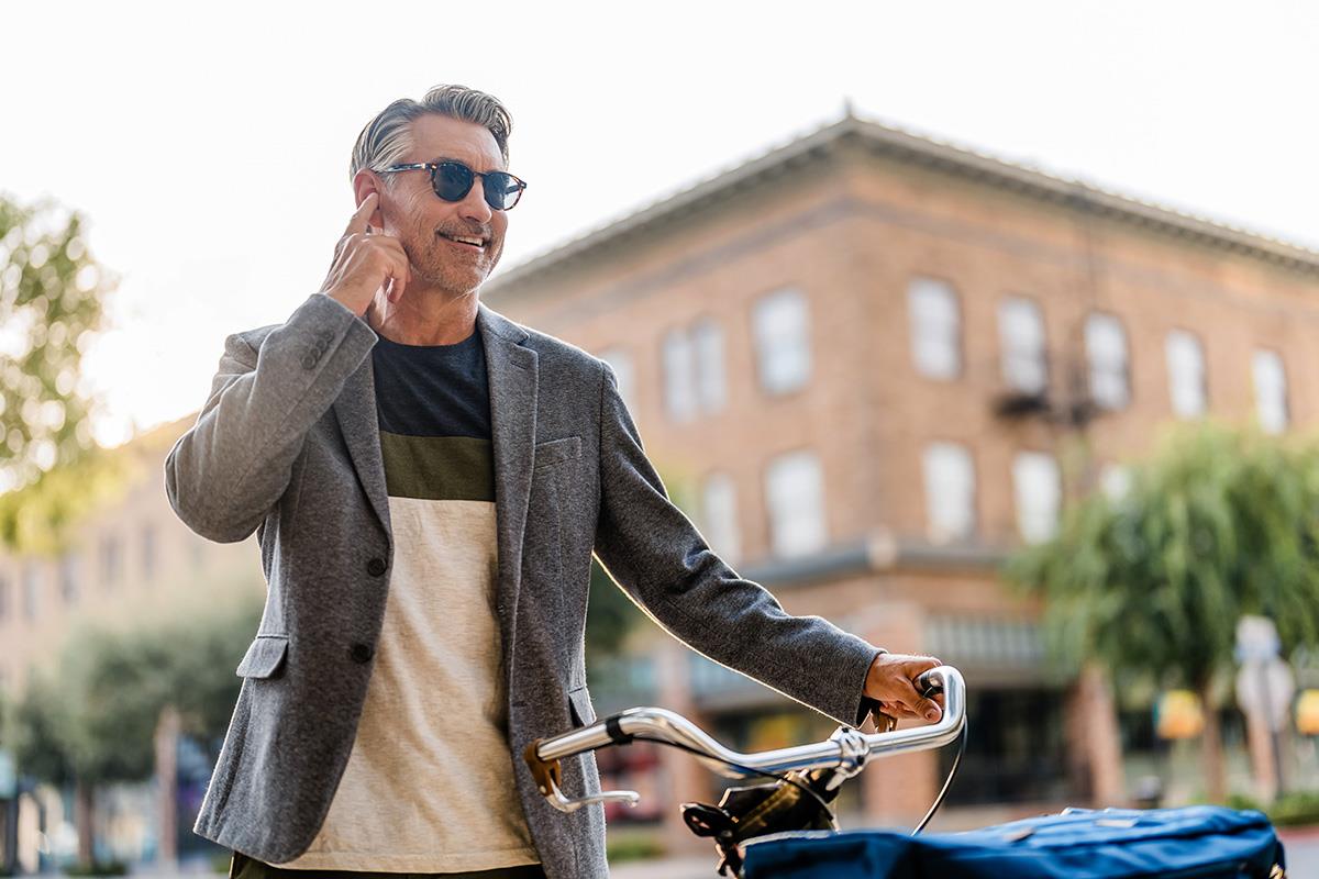 Man holding his bicycle and talking on the telephone