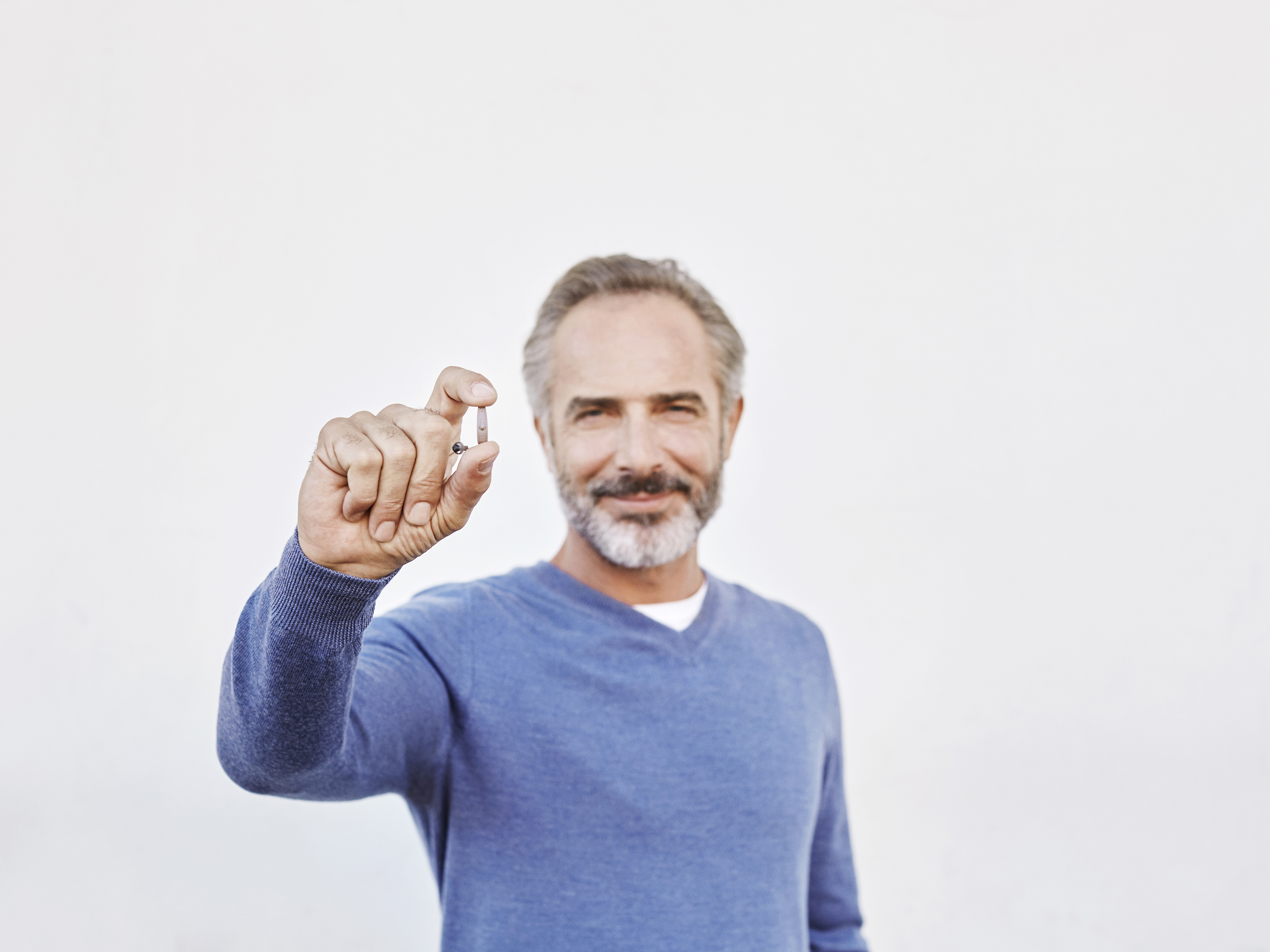 Man holding Receiver-in-ear hearing aid | Beltone Trust