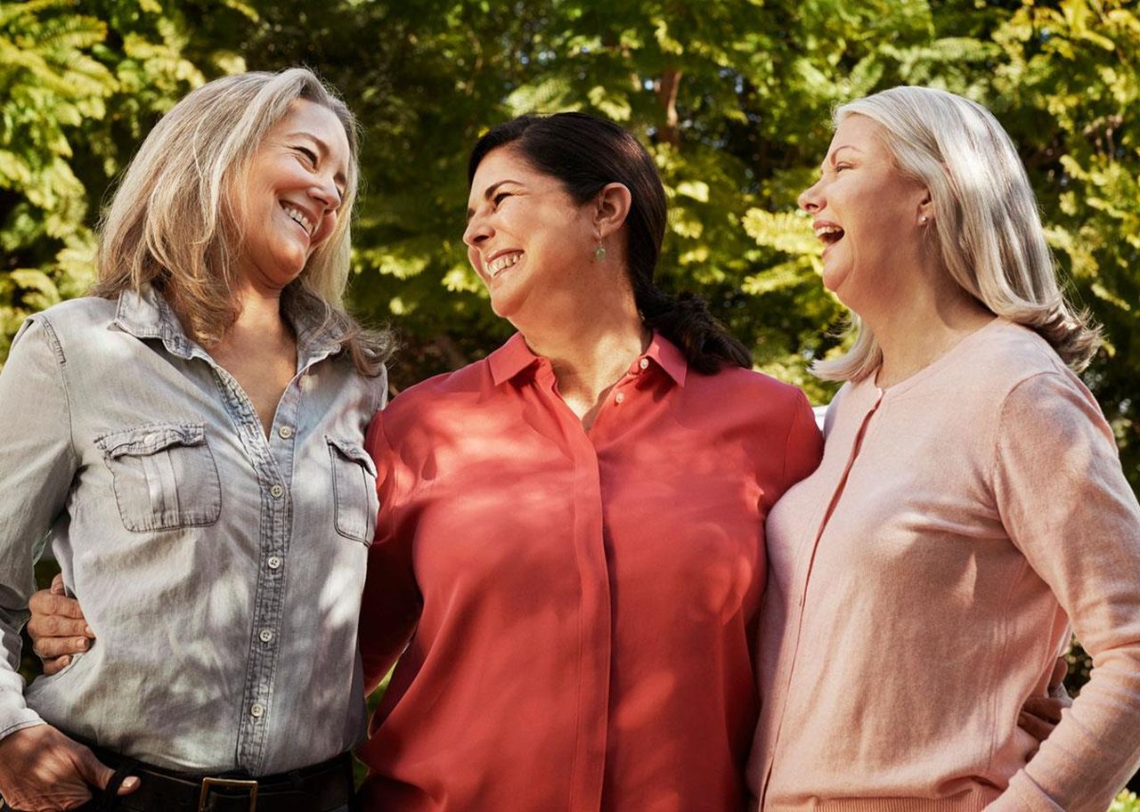 Women wearing hearing aids smiling with each other