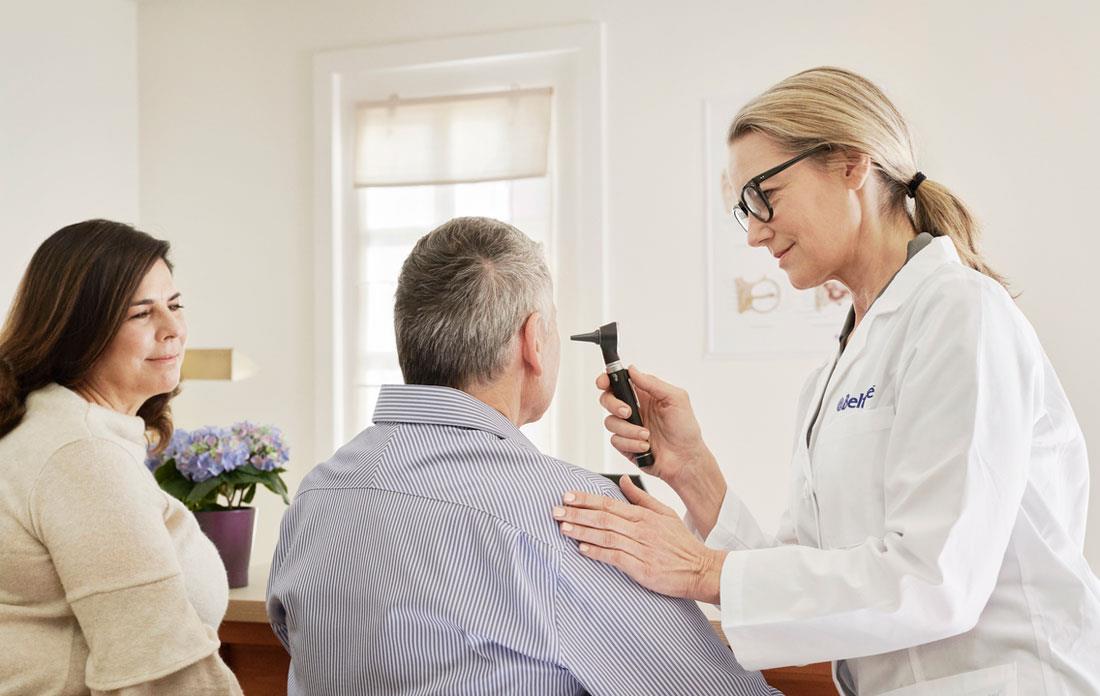 hearing care professional checking a patient's ear