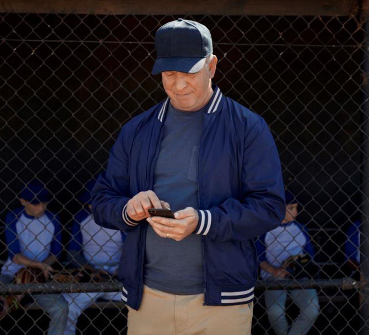 Uomo che usa l'app Beltone Hearplus sulla spiaggia